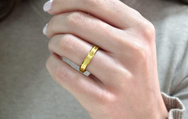 Wedding ring in solid gold with decorative line.
