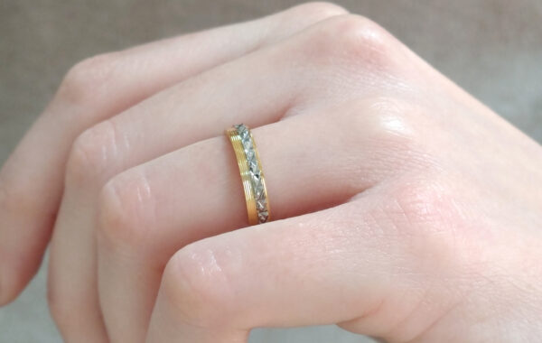 Wedding ring in solid gold with two colors with decorative geometric elements.