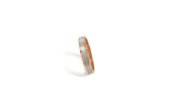 Wedding ring in solid gold with two colors and decorative lines.