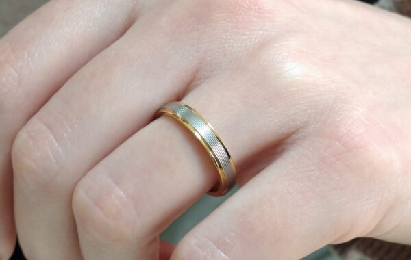 Wedding ring in solid gold with two colors and decorative lines.