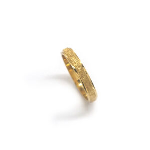 Wedding ring in solid gold with texture.