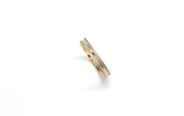 Wedding ring in solid gold with two colors and decorative lines.