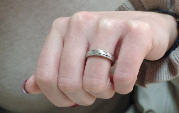 Wedding ring in solid gold with decorative lines.