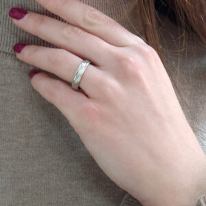 Wedding ring in solid gold with decorative lines.