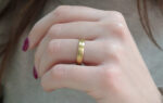 Wedding ring in solid gold with decorative lines.
