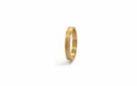 Wedding ring in solid gold with a shiny diamond finish line.