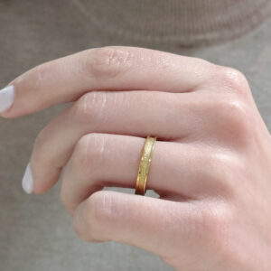 Wedding ring in solid gold with a shiny diamond finish line.