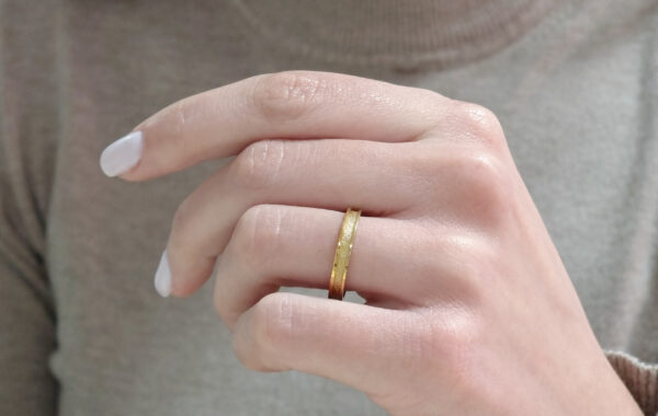 Wedding ring in solid gold with a shiny diamond finish line.