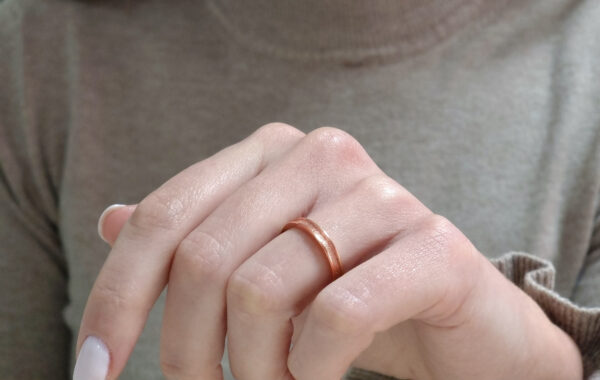 Wedding ring in solid gold with a shiny diamond finish line.