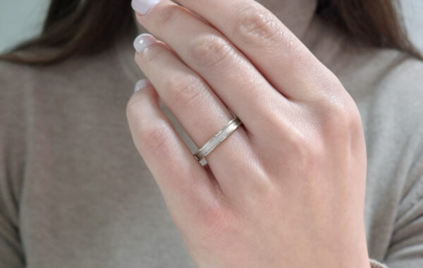 Wedding ring in solid gold with a shiny diamond finish line.